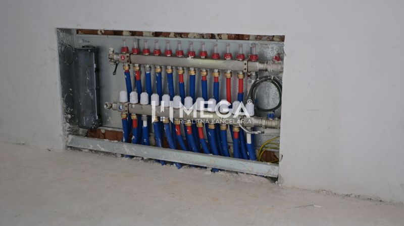 Verteilerkasten der Installationen im Innenbereich eines Einfamilienhauses mit blauen und roten Rohren.