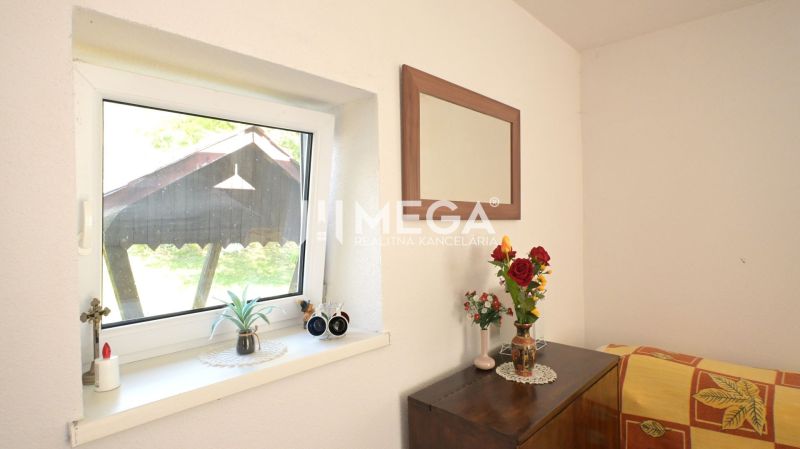 Ein Blumenstrauß und ein Spiegel in einem Einfamilienhaus, minimalistische Dekoration und Holzmöbel im Interieur.