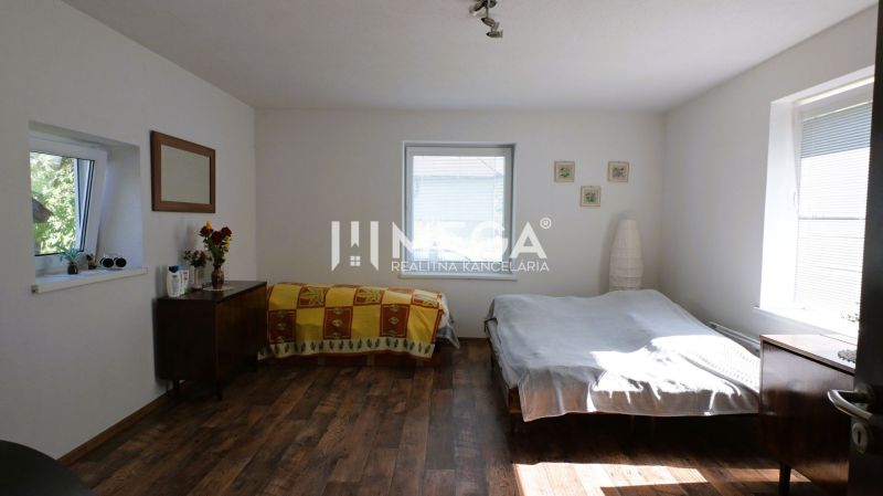 Schlafzimmer im Einfamilienhaus mit Bett, Schrank und Boden mit Holzdekor.