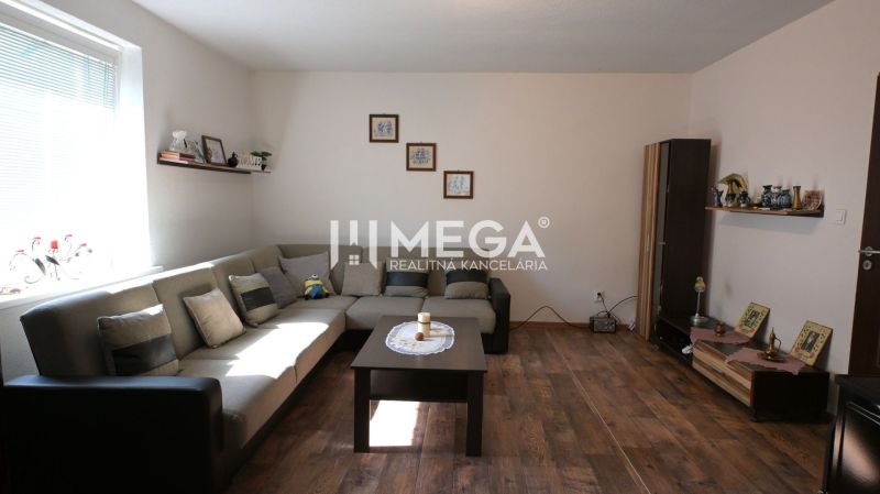Wohnzimmer mit Sofa, Tisch und Holzboden in einem Einfamilienhaus.