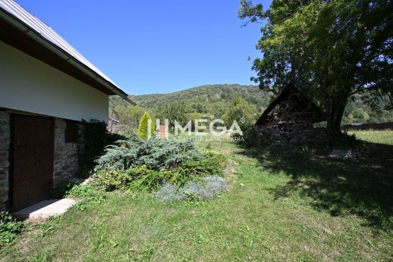 Der Garten beim Einfamilienhaus in Kolbasov mit üppiger Vegetation und Blick auf die umliegenden Hügel.