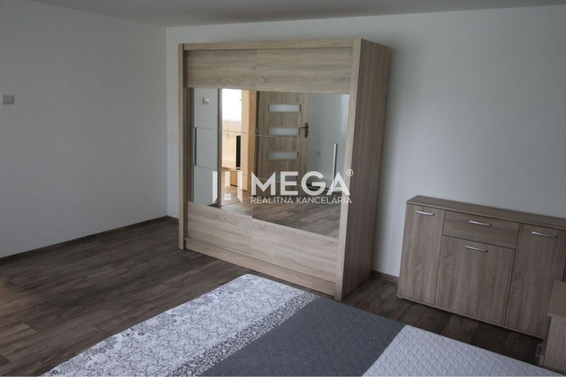 Schlafzimmer mit einem Spiegelschrank und einer Kommode in einem Einfamilienhaus mit einem Boden in Holzoptik.