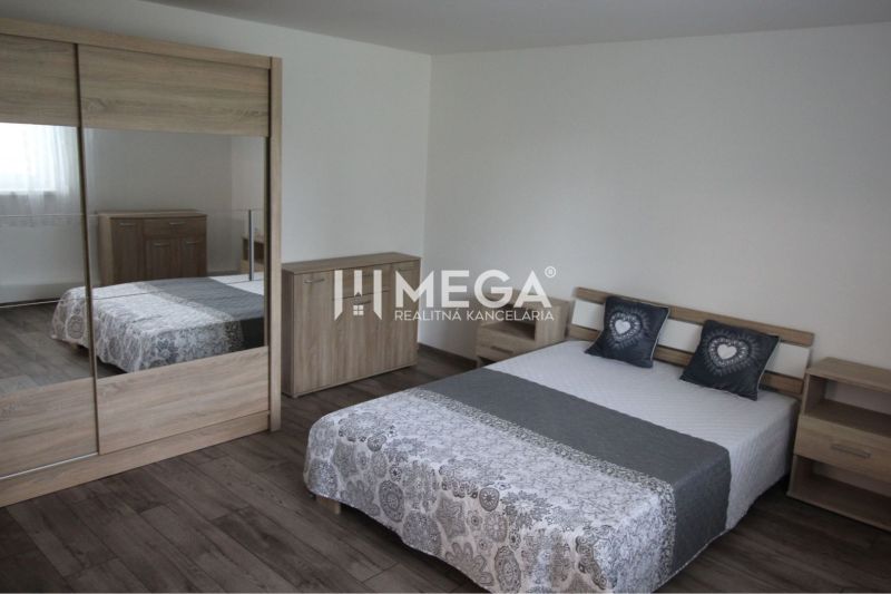 Ein Schlafzimmer in einem Einfamilienhaus mit einem Boden in Holzoptik und Holzmöbeln.