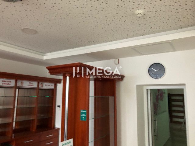 Der Innenraum des Gebäudes mit Glasvitrinen und einer Uhr an der Wand.