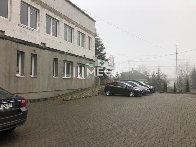 Ein Gebäude in der SNP-Straße in Snina mit einem Parkplatz vor dem Objekt und geparkten Autos.