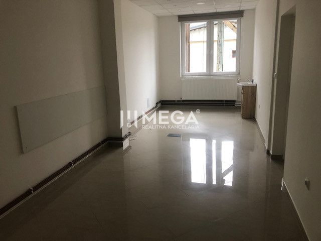 Innenraum eines Gebäudes mit Holzboden und großem Fenster.