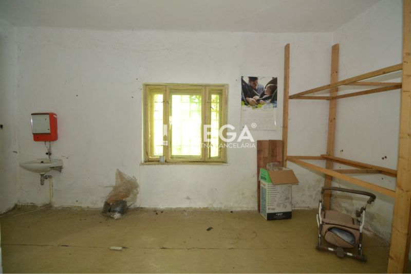 Gewerbefläche mit einfachem Waschbecken, Regalen und Fenster, ohne Bodenbelag mit Holzdekor.