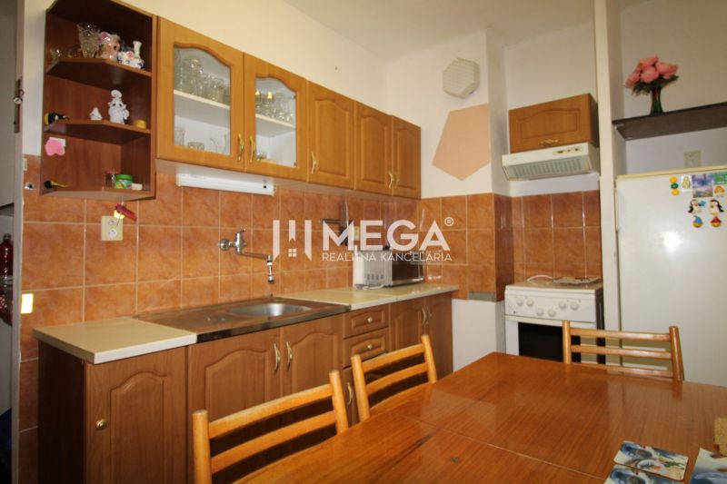Küche in einer 3-Zimmer-Wohnung mit Holzmuster-Küchenzeile und Keramikfliesen.