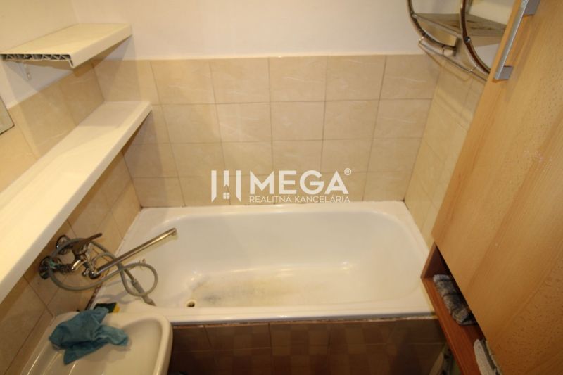 Badezimmer mit Badewanne in einer 3-Zimmer-Wohnung, einfache Fliesen und wenig Stauraum.