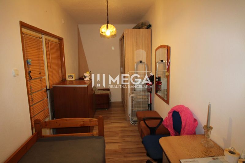 Gemütliches Zimmer mit Holzboden und Möbeln in einer 3-Zimmer-Wohnung.