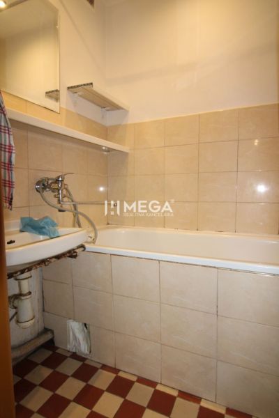 Badezimmer in einer 3-Zimmer-Wohnung mit Badewanne und Fliesen in Beigetönen.