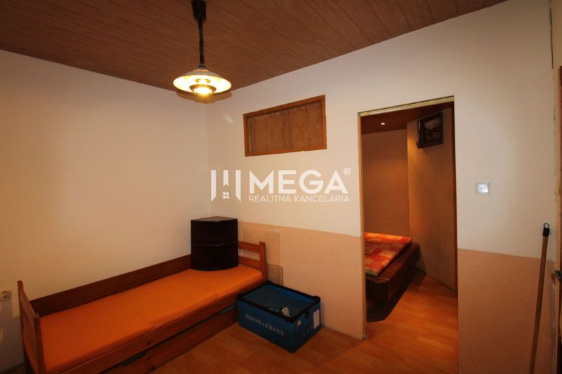 Ein Zimmer in einer 3-Zimmer-Wohnung mit einem Bett, einer Lampe und einem Boden in Holzoptik.