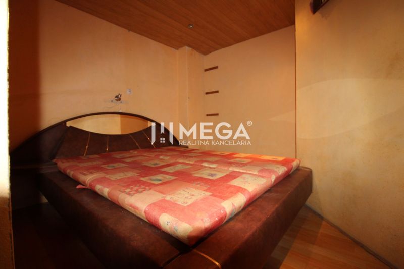 Schlafzimmer in einer 3-Zimmer-Wohnung mit einem großen Bett und einem Boden in Holzoptik.