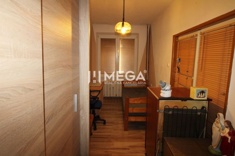 Kinderzimmer in einer 3-Zimmer-Wohnung mit Schreibtisch, Schrank und Boden mit Holzdekor.