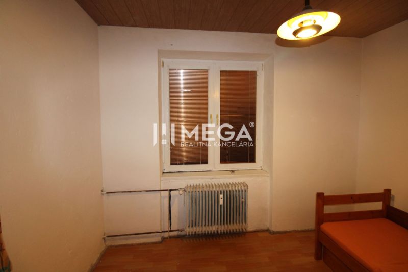 Ein Zimmer in einer 3-Zimmer-Wohnung mit einem Boden in Holzoptik und einem zentral platzierten Heizkörper.