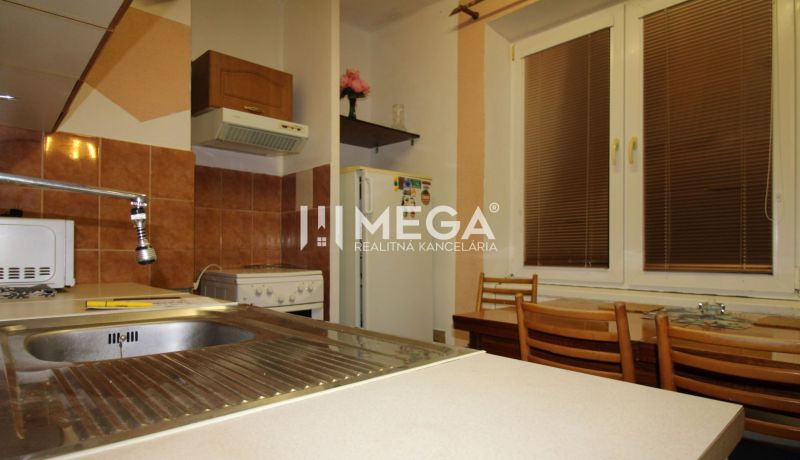 Küche in einer 3-Zimmer-Wohnung mit Spüle, Kühlschrank, Herd und Holzstühlen.