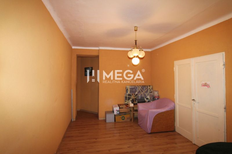 Ein Zimmer in einer 3-Zimmer-Wohnung mit einem Boden in Holzoptik und einer Vintage-Leuchte.