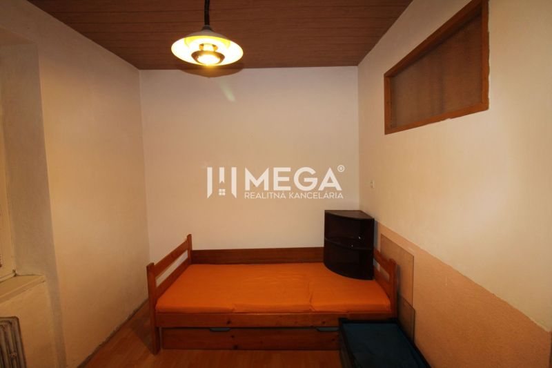 Ein Zimmer mit einem Bett und einem Nachttisch in einer 3-Zimmer-Wohnung mit Holzboden.