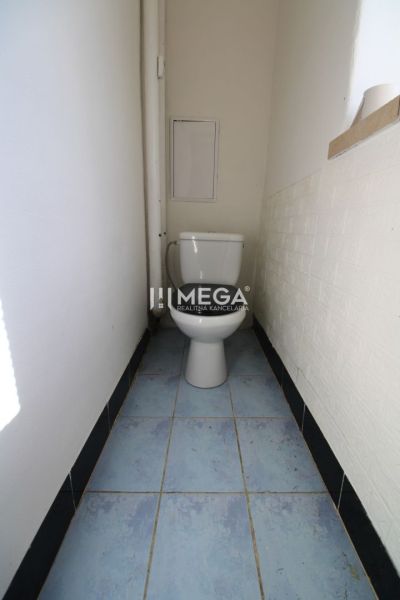 Badezimmer in einer 3-Zimmer-Wohnung mit Toilette und blauen Fliesen.