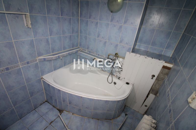Badezimmer mit blauen Fliesen und Badewanne in einer 3-Zimmer-Wohnung.