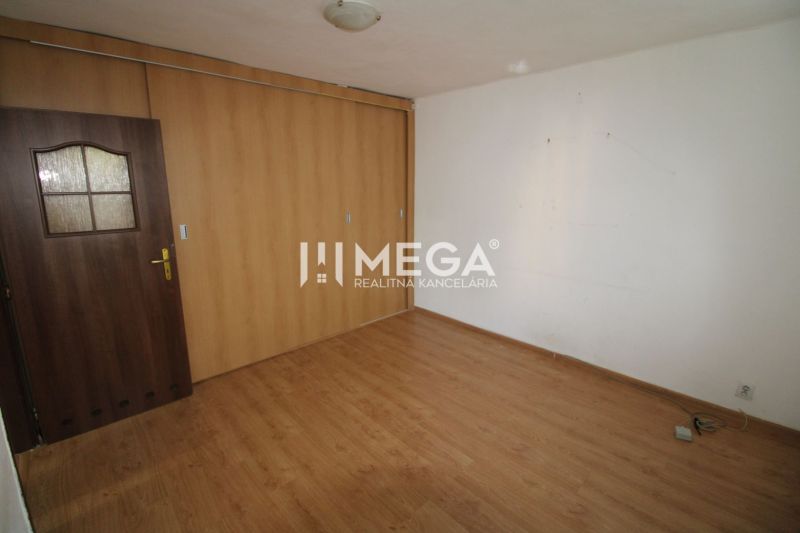 Ein Zimmer in einer 3-Zimmer-Wohnung mit einem Boden in Holzoptik und einem Einbauschrank.