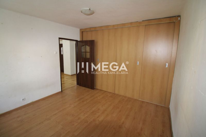 Ein Zimmer in einer 3-Zimmer-Wohnung mit Holzboden und Einbauschrank.