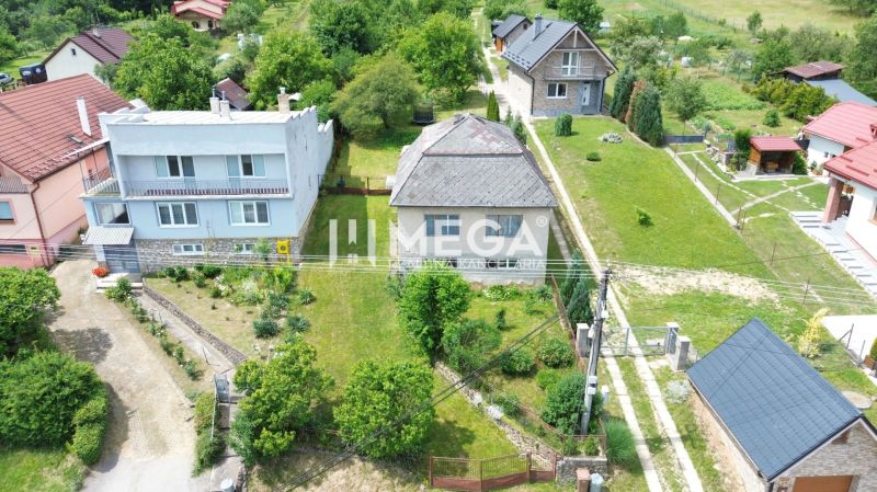 Ein Einfamilienhaus in der Jesenského-Straße in Snina, umgeben von einem Garten und umliegenden Häusern.