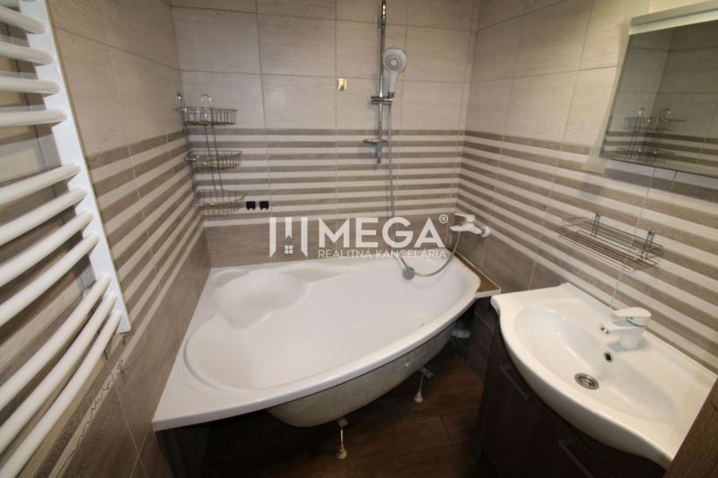 Badezimmer in einer 3-Zimmer-Wohnung mit Eckbadewanne und Boden in Holzoptik.