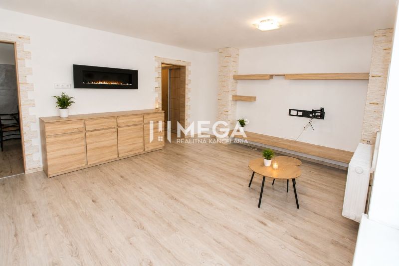 Wohnzimmer in einer 3-Zimmer-Wohnung mit Holzboden, hellen Wänden und Möbeln.