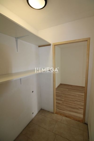 Eingangsbereich mit Regalen und Boden in Holzdekor in einer 3-Zimmer-Wohnung.