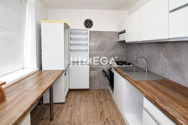 Küche in einer 3-Zimmer-Wohnung mit Holzboden und eleganter Küchenzeile.