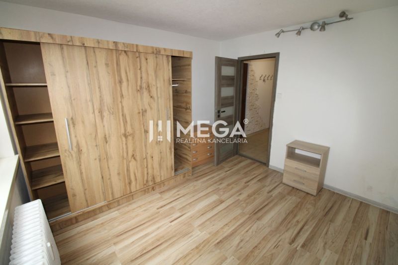 Ein Zimmer mit einem Holzboden und einem Einbauschrank in einer 3-Zimmer-Wohnung.