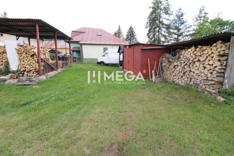 Der Hof des Einfamilienhauses in Ulič, Ulič 131, Rasen, gelagertes Holz und Unterstand.