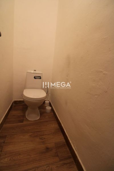 Toilette in einer 2-Zimmer-Wohnung mit Holzboden.