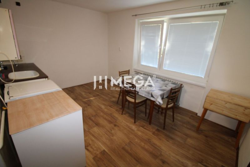 Küche in einer 2-Zimmer-Wohnung mit Holzboden und Esstisch.