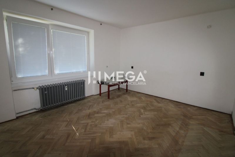 Ein Zimmer mit Holzboden und Heizkörper in einer 2-Zimmer-Wohnung.
