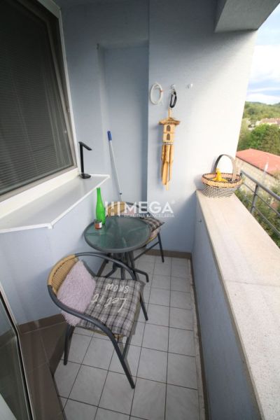 Balkon einer 2-Zimmer-Wohnung mit einem Café-Tisch und Blick ins Grüne.