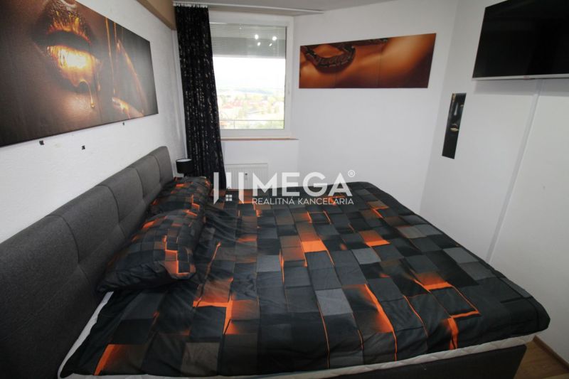 Schlafzimmer in einer 2-Zimmer-Wohnung mit Bett und künstlerischen Dekorationen an der Wand.