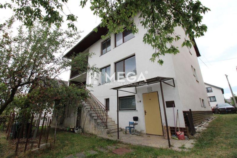 Ein Einfamilienhaus in der Straße in Snina mit zwei Etagen, Bäumen und einer Außentreppe.