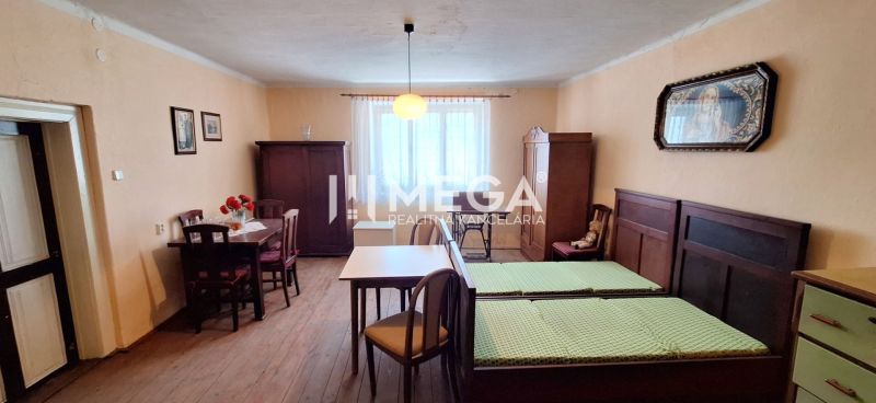 Ein Zimmer in einem Einfamilienhaus mit Holzelementen, antiken Möbeln und einfacher Beleuchtung.