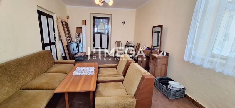 Wohnzimmer in einem Einfamilienhaus mit antiken Möbeln und Sitzgarnitur.