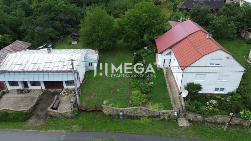 Ein Haus mit rotem Dach in Oľšinkovo auf der Oľšinkov-Straße, umgeben von einem Garten. Grundstücke - Wohnen.