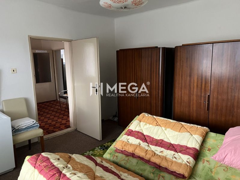 Ein Schlafzimmer in einem Einfamilienhaus mit Bett, Einbauschrank und offenen Türen.
