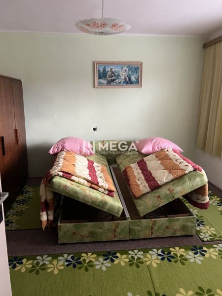 Ein Schlafzimmer in einem Einfamilienhaus mit zwei Betten, einem grünen Teppich und einem Bild an der Wand.