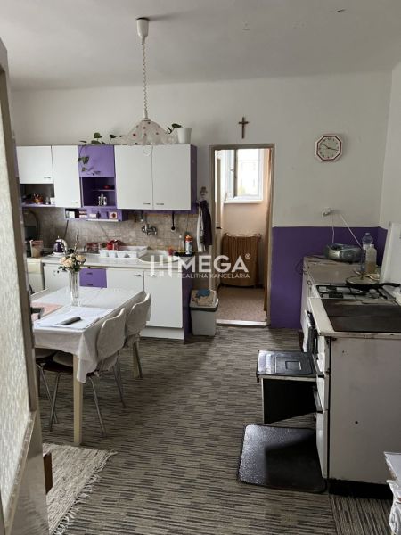 Küche in einem Einfamilienhaus mit violetten Schränken und Esstisch.