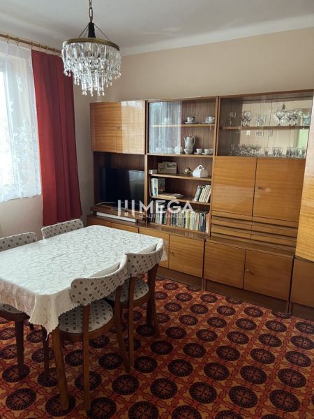 Esszimmer in einem Einfamilienhaus mit Retro-Möbeln, Teppich, Kronleuchter, Vorhänge.