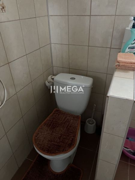 Badezimmer im Einfamilienhaus mit Toilette, Fliesenboden und Wandfliesen.