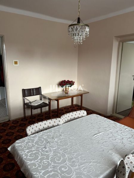 Esszimmer in einem Einfamilienhaus mit einem hängenden Kronleuchter und Blumen auf dem Tisch.