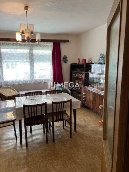 Esszimmer eines Einfamilienhauses mit Holzboden, Esstisch und Vitrine.