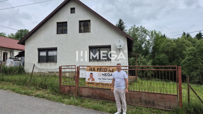 Ein Einfamilienhaus in Zboj mit einem Grundstück, das von einem Metallzaun umgeben ist, und einem großen Garten.